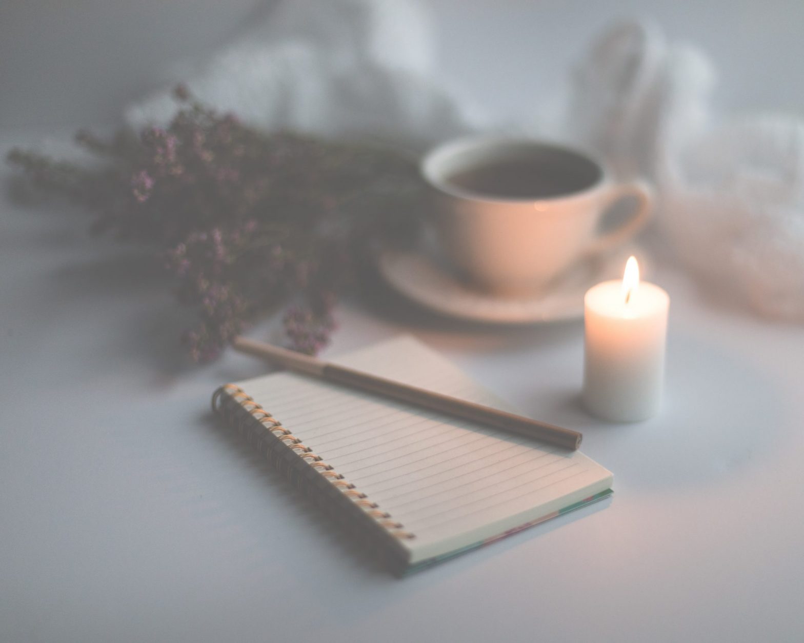 notebook by candle and coffee