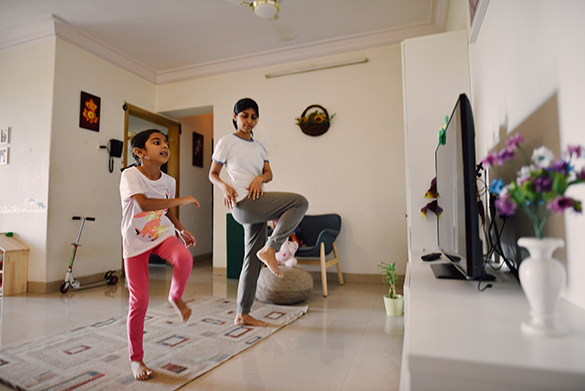 two kids in living room dancing