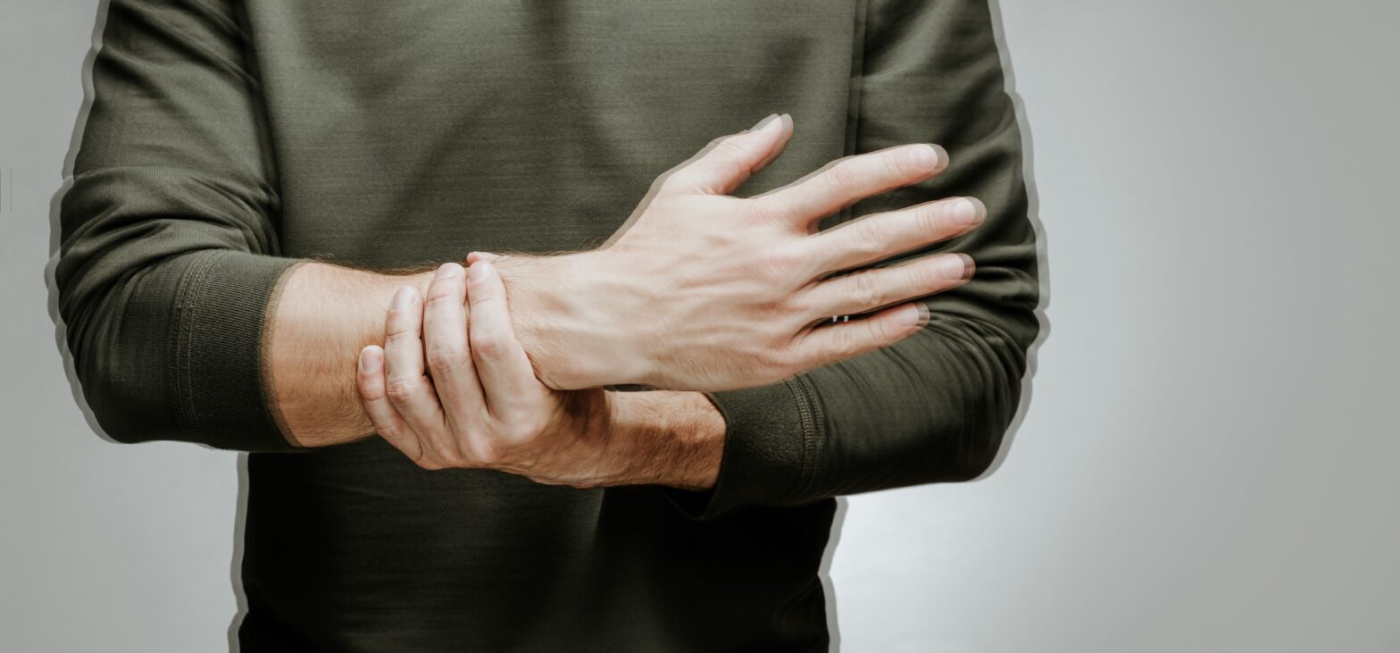 Person with Parkinson's Disease steadying trembling hand